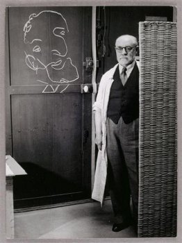 Henri Matisse in piedi contro uno schermo e disegno con il gesso